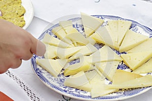Dish of Manchego Curado cheese pieces cut in triangles photo