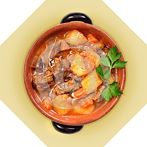 Dish of meat soup with potatoes in ceramic pot.