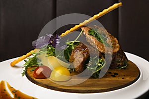 Dish of meat and vegetables on a wooden tray