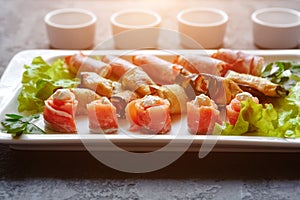 A dish with mini-canapes of salmon, eggplant and ham rolls with different fillings for a buffet and a festive table