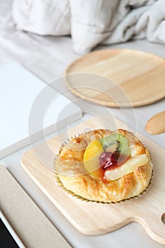 Dish of mixed fruits pies is on top of the bed. Breakfast in bed concept