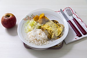 Dish of omelet, pumpkin and cabbage, with dish neglect and with cutlery and apple for dessert.