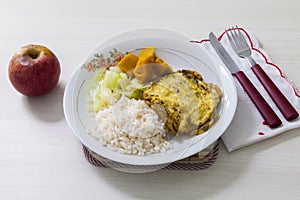 Dish of omelet, pumpkin and cabbage, with dish neglect and with cutlery and apple for dessert.