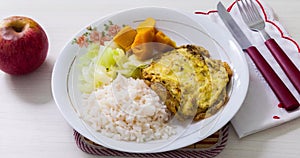 Dish of omelet, pumpkin and cabbage, with dish neglect and with cutlery and apple for dessert.
