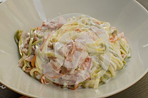 The dish `Paglia e fieno al prosciutto` - typical italian food photo