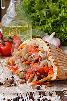 A dish of pita bread stuffed with grilled meat, then chopped meat and fresh vegetables.