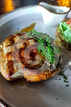 A dish of pork medallion with dill close-up with sauce