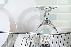 Dish rack with clean dry dishes on kitchen counter