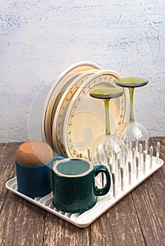 Dish rack with clean dry dishes on kitchen counter