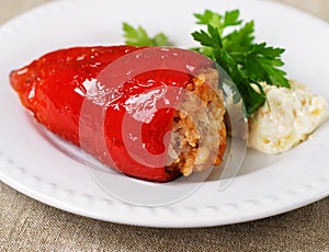 A dish of red peppers with greenstuff photo