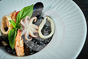 Dish of risotto with squid ink on grey plate jpg