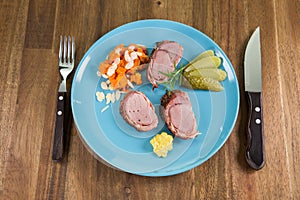 Dish with roast pork, vegetables and mayonnaise on a blueish plate