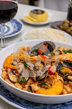 A dish of seafood feijoada with rice, garnished with shrimp and clams. photo