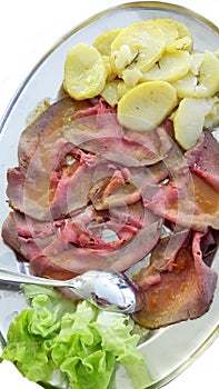 A dish with slices roastbeef and potatoes