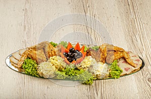 Dish from tartlets and chicken wings with the presence of lettuce leaves.