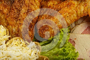 Dish from tartlets and chicken wings with the presence of lettuce leaves.