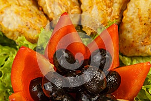 Dish from tartlets and chicken wings with the presence of lettuce leaves.