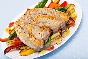 Dish of tasty baked scomber with different vegetables at plate