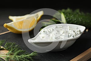 Dish of Tzatziki sauce with lemon slices, cucumber and dill photo