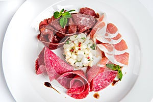 Dish of various types of meat-cutting on plate.