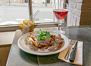 A dish of veal kidneys with juniper berries and juniper vodka enever. Also fries and ruby beer. A traditional Belgian dish