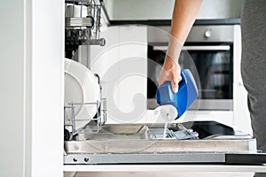 Dish washing machine. Washer in kitchen. Open dishwasher in modern white home. Full of clean plates.