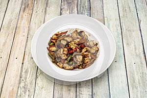 Dish of wok chicken with soy sauce, chopped red and green peppers,