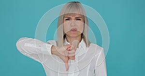 Disheartened Caucasian Woman Showing Thumbs Down on Blue Background