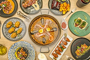 Dishes of different nationalities served in a fusion restaurant. Seafood paella, Galician mussels in sauce, black rice, Mexican