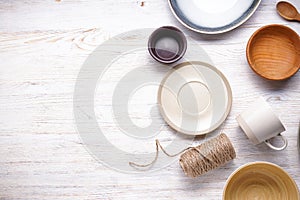 Dishes for serving and eating meals with space for text, top view. Modern ceramic and wooden crockery, trendy tableware