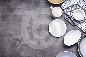 Dishes for serving and eating meals on a wooden background, space for text, top view. Modern ceramic and wooden crockery, trendy