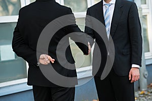 Dishonest Businessman Shaking Hands With Partner