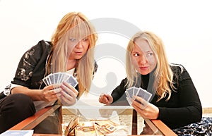 Dishonesty - a cunning girl cheating her friend while playing card game for money