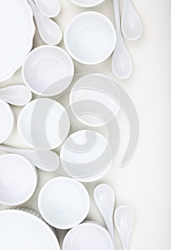 Dishware concept. White empty porcelain bowls and teaspoons on white background