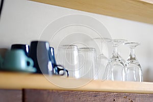 Dishware. Mugs, cups, glasses are on a wooden shelf. Kitchen accessories and utensil