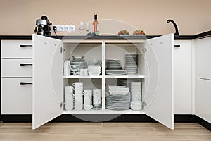 Dishware storage cabinet with plates and cups inside