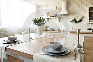 Dishware on table in modern dining room or kitchen interior, selective focus. Modern Scandinavian style home design