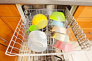 Dishwasher with clean utensils drying in it`s rack photo