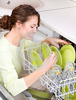 Dishwasher. Young woman doing Housework