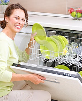 Dishwasher. Young woman doing Housework