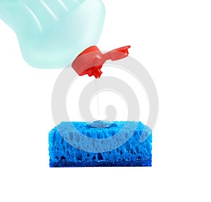 Dishwashing liquid is poured from a blue plastic bottle with a red cork on a blue rectangular sponge. Isolated on a white