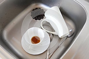 Dishwashing. White dishes in the kitchen sink.