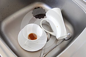 Dishwashing. White dishes in the kitchen sink.