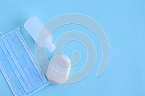 Disinfectants for the virus - a mask, soap, disinfectant in a bottle are on a blue background. Flat lay