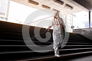 Disinfection of the city from coronavirus, a man in a protective suit and a respirator cleans the street with a chemical spray, a