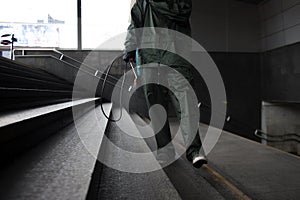 Disinfection of the city. a man in a protective suit cleans the steps with a chemical agent