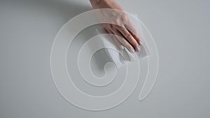 Disinfection concept - woman cleaning white table with wet wipe - slow motion