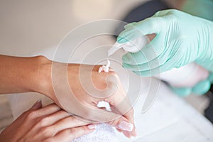 Disinfection hands before manicure in the salon closeup. Beautician is disinfecting client`s with desinfectant photo