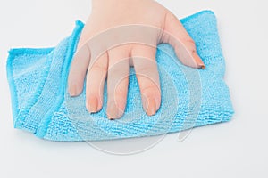 Disinfection of premises, general cleaning. Female hand wipes a white surface with a blue microfiber cloth