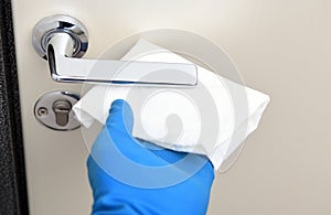 Disinfection in public places, the fight against the virus, coronavirus.Worker`s hand wipes the door handles. A maid or housewife